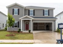 Charming two-story home featuring gray siding, black shutters, a red front door, and an attached two-car garage at 2234 Cherry Creek Rd, Haw River, NC 27258