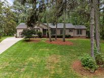 Charming ranch home with lush front lawn and mature trees creating a serene curb appeal at 5109 Knaresborough Rd, Raleigh, NC 27612