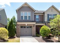 Charming townhome featuring a brick facade, attached garage, and well-maintained landscaping at 628 Denhoff Dr, Cary, NC 27519