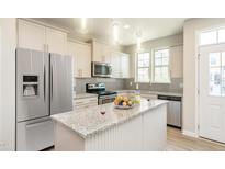 Modern kitchen with granite counters, stainless appliances and a large island, perfect for entertaining at 6445 Granite Quarry Dr, Raleigh, NC 27610