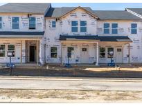 Unfinished new construction townhomes with black roof and Tyvek wrap ready for customization and personalization at 713 Chandler Stone Dr, Zebulon, NC 27597