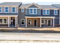 New construction townhomes feature brick accents, covered entryways, and neutral color schemes at 713 Chandler Stone Dr, Zebulon, NC 27597