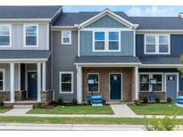 Charming townhome featuring a colorful exterior with a well-manicured lawn and inviting front porch at 713 Chandler Stone Dr, Zebulon, NC 27597