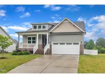 Charming home with an attached two-car garage, a welcoming porch, and a well-manicured front yard at 9 Little Sunshine Brk, Smithfield, NC 27577