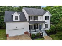 Beautiful two-story home with white siding, black shutters, covered porch, and attached two-car garage at 100 Citrus Pl, Cary, NC 27519