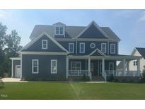 Beautiful two-story home with a manicured lawn, inviting front porch, and classic architectural details at 1017 Azalea Garden Cir, Raleigh, NC 27603