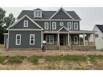 Two-story home featuring a charming facade with a covered front porch and craftsman-style details at 1017 Azalea Garden Cir, Raleigh, NC 27603