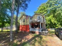 Charming multi-level home featuring a spacious porch and upper balcony at 103 N Woods Rd, Henderson, NC 27536