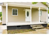 Inviting covered front porch with classic white columns and steps leading to the front door at 1309 Jackson St, Burlington, NC 27217