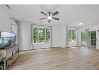 Bright living room features hardwood floors, a ceiling fan, and large windows at 1723 Kudrow Ln, Morrisville, NC 27560