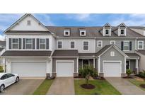 Charming townhome with attached garages, manicured lawn, and classic architectural details at 19 Willow Green Dr, Clayton, NC 27527