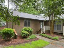 Charming brick home featuring a landscaped front yard and a welcoming entryway with a white railed porch at 200 W Woodcroft Pkwy # 52A, Durham, NC 27713