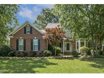 Charming brick home with manicured lawn, mature trees, and welcoming front porch at 2030 Prairie Ridge Ct, Fuquay Varina, NC 27526