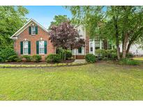Charming brick home with a well-manicured lawn and lush landscaping, enhancing its curb appeal at 2030 Prairie Ridge Ct, Fuquay Varina, NC 27526
