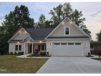 Charming home with a white brick exterior, manicured lawn and a two car garage at 2112 Coy St, Burlington, NC 27215