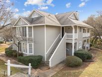 Inviting two-story home with exterior stairs, mature landscaping, and light gray siding at 2821 Edridge Ct, Raleigh, NC 27612