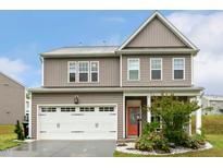 Charming two-story home featuring a two-car garage, a cozy front porch, and landscaped front yard at 307 W Copenhaver Dr, Clayton, NC 27527