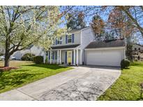 Charming two-story home with a yellow door, blue shutters, and beautiful landscaping at 4508 Cobble Creek Ln, Raleigh, NC 27616