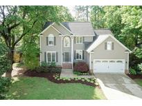 Charming two-story home with manicured lawn and attached two car garage offers curb appeal at 5609 Barham Ct, Raleigh, NC 27613