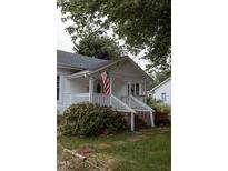 Charming home with a covered porch, stone steps, and an American flag on display at 6 1St St, Franklinton, NC 27525
