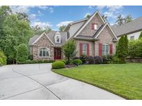 Charming two-story home with brick and stone exterior, red shutters, and a well-manicured lawn at 605 Bear Tree Crk, Chapel Hill, NC 27517
