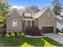 Charming brick home featuring manicured lawn and welcoming front porch at 6648 Mafolie Ct, Raleigh, NC 27613