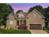Charming brick home with a manicured lawn and lovely landscaping at 6648 Mafolie Ct, Raleigh, NC 27613