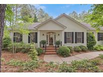 Charming home featuring a well-manicured lawn, black shutters, and brick stairs leading to the front door at 826 Rushing, Pittsboro, NC 27312