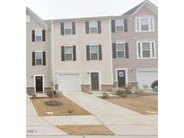 Charming townhomes featuring individual garages and matching front doors and trim details at 904 Romeria Dr, Durham, NC 27713