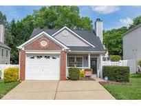 Charming single-Gathering home features a brick facade, attached garage, manicured lawn and cozy front porch at 9919 Treymore Dr, Raleigh, NC 27617