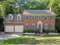 Charming brick home featuring blue shutters, a well-manicured lawn, and a two-car garage at 1013 New Chester Ct, Apex, NC 27502
