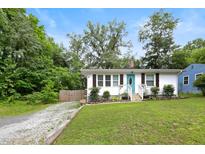 Charming home featuring a well-maintained lawn, inviting blue front door, and ample natural light at 1014 E Club Blvd, Durham, NC 27704
