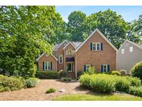 Charming brick home with lush landscaping, gabled roof, and inviting curb appeal at 1025 Kingsway Dr, Apex, NC 27502