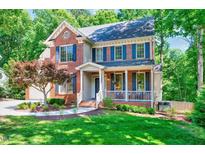 Charming two-story brick home with a well-manicured lawn and inviting front porch at 105 Wittenham Dr, Cary, NC 27519