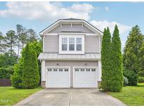 Two-story home features a two-car garage and manicured evergreens in the front yard at 13 Pegram Ct, Durham, NC 27703