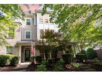 Inviting townhome showcasing manicured landscaping, brick accents, and a charming covered entrance at 1427 Van Page Blvd, Raleigh, NC 27607