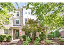 Charming townhouse featuring brick and siding, complemented by a well-manicured lawn and mature trees at 1427 Van Page Blvd, Raleigh, NC 27607
