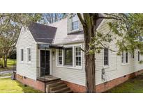 Charming home featuring a blend of siding, brick foundation, and a welcoming black front door at 1512 Oxford Rd, Henderson, NC 27536