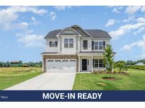 Charming two-story home with a well-manicured lawn and attached two-car garage at 162 Tuskeegee Dr, Smithfield, NC 27577