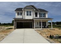 New two-story home featuring a stone-accented garage and charming front porch at 162 Tuskeegee Dr, Smithfield, NC 27577