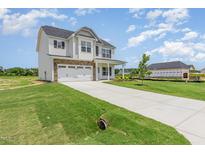 Two-story home with stone accents, attached two-car garage, and a long concrete driveway at 162 Tuskeegee Dr, Smithfield, NC 27577