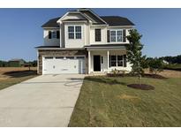 Charming two-story home featuring a stone-accented garage, manicured lawn, and classic architectural details at 162 Tuskeegee Dr, Smithfield, NC 27577