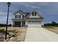Charming two-story home featuring a two-car garage, light gray siding and a concrete driveway at 188 Tuskeegee Dr, Smithfield, NC 27577
