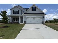 Charming two-story home features a two-car garage and a well-manicured lawn at 188 Tuskeegee Dr, Smithfield, NC 27577
