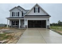 New two-story home featuring an attached two-car garage, gray siding, and a covered front porch at 188 Tuskeegee Dr, Smithfield, NC 27577