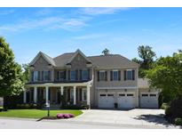 Charming two-story home featuring a three-car garage and a welcoming front porch at 1927 Napoli Dr, Apex, NC 27502