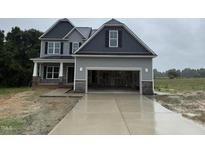 Two-story home featuring an attached two car garage, gray siding and black shutters at 202 Tuskeegee Dr, Smithfield, NC 27577