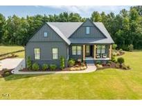 Beautiful two-story home with a manicured lawn and inviting front porch at 223 Lindo Johnson Rd, Pittsboro, NC 27312