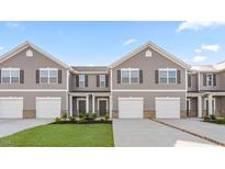 Attractive townhomes boast gray siding, white garage doors, manicured lawns, and a welcoming neighborhood vibe at 235 Moyer Dr # 191, Graham, NC 27253