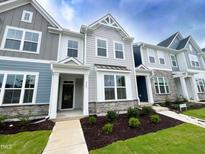 Beautiful townhome with stone accents, manicured lawn, and inviting covered entryway at 2403 Whitewing Ln, Wendell, NC 27591
